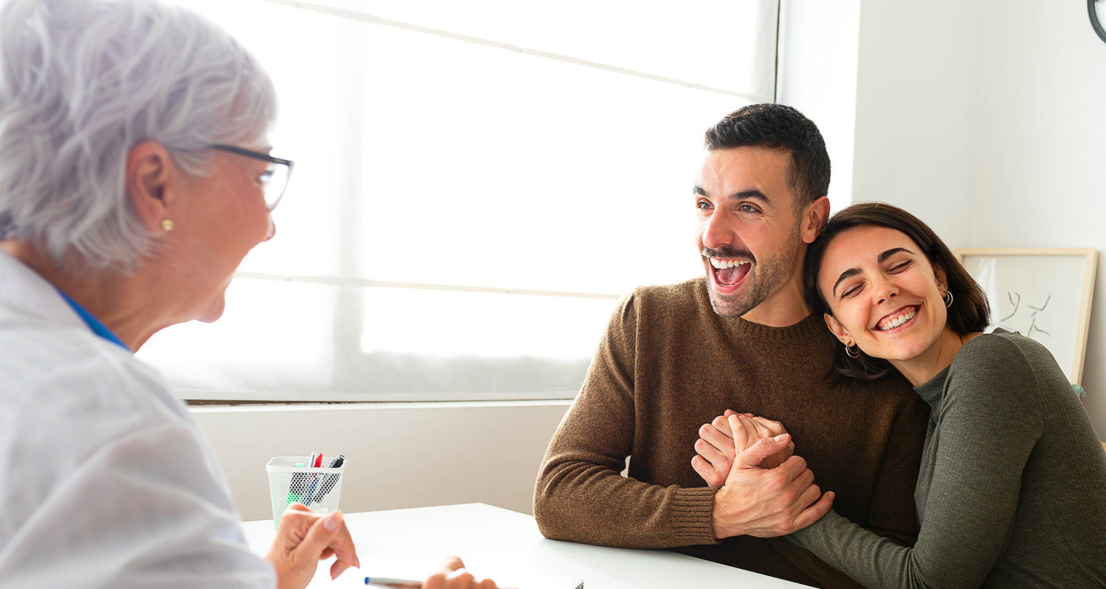 A happy and excited married couple receive good news from their fertility specialist