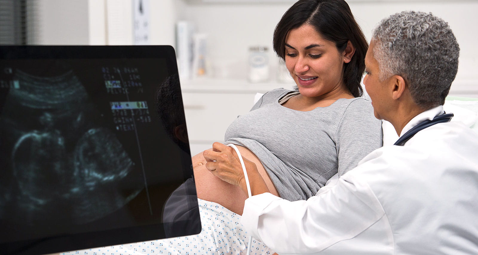A doctor giving pregnant patient ultrasound