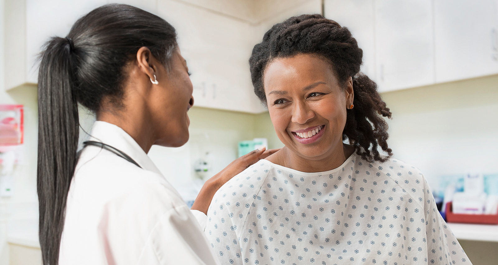 A doctor comforting her patient in her office
