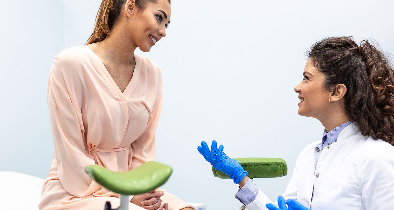 A gynecologist talking with a young female patient during a medical consultation