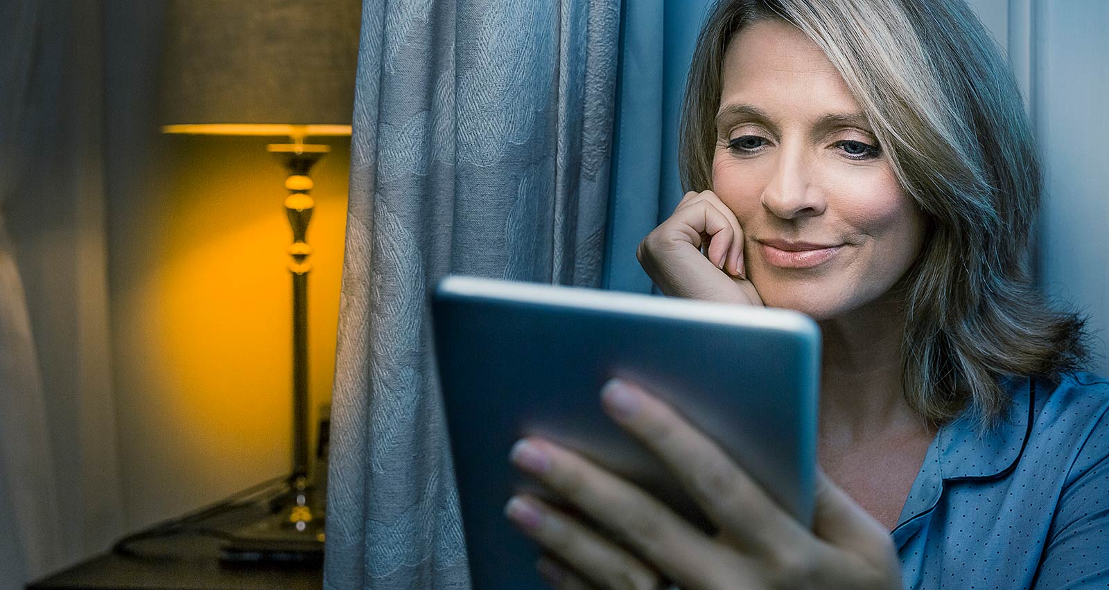 Mature woman using digital tablet while sitting at home