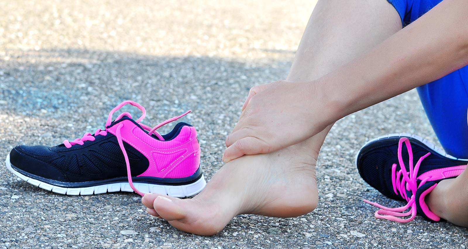 A female runner holds her injured ankle