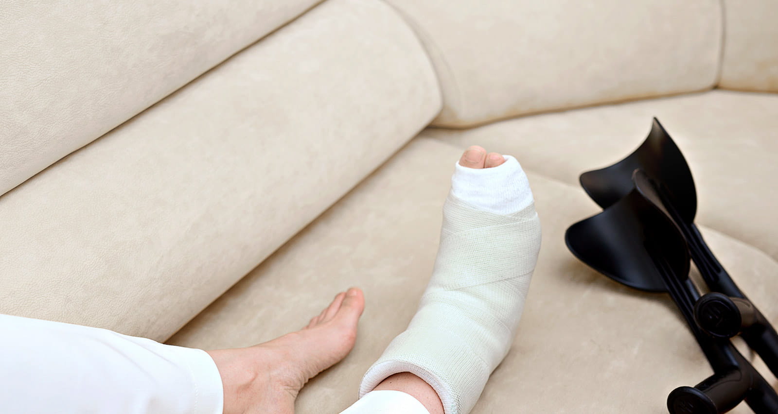 A woman with a foot bone fracture relaxes on her couch