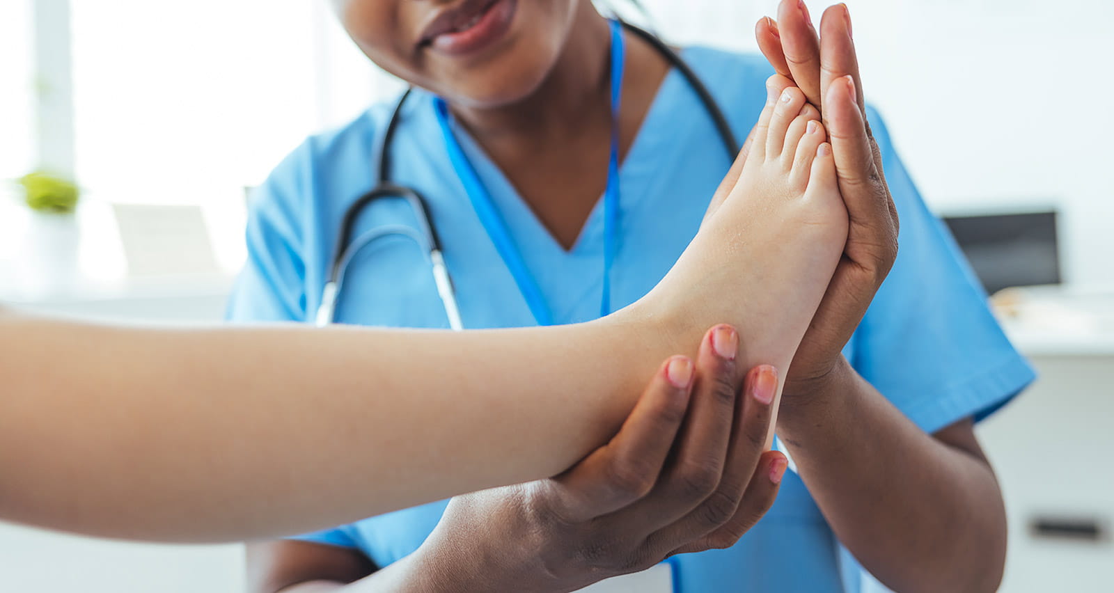 A female doctor examining a child’s foot in hospital