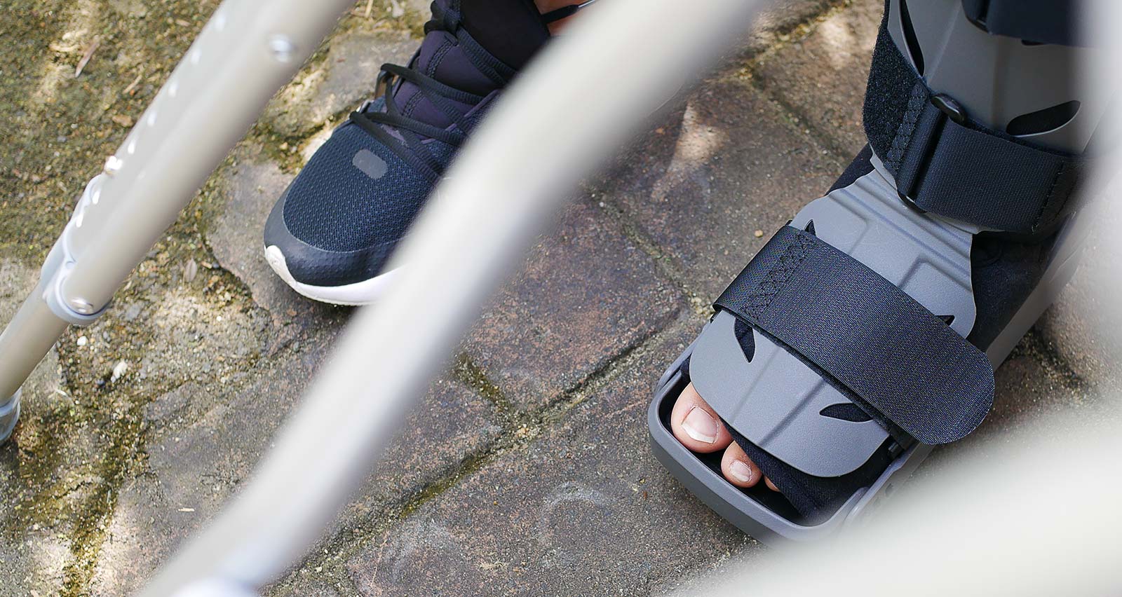 A woman with a broken foot wears a grey plastic boot