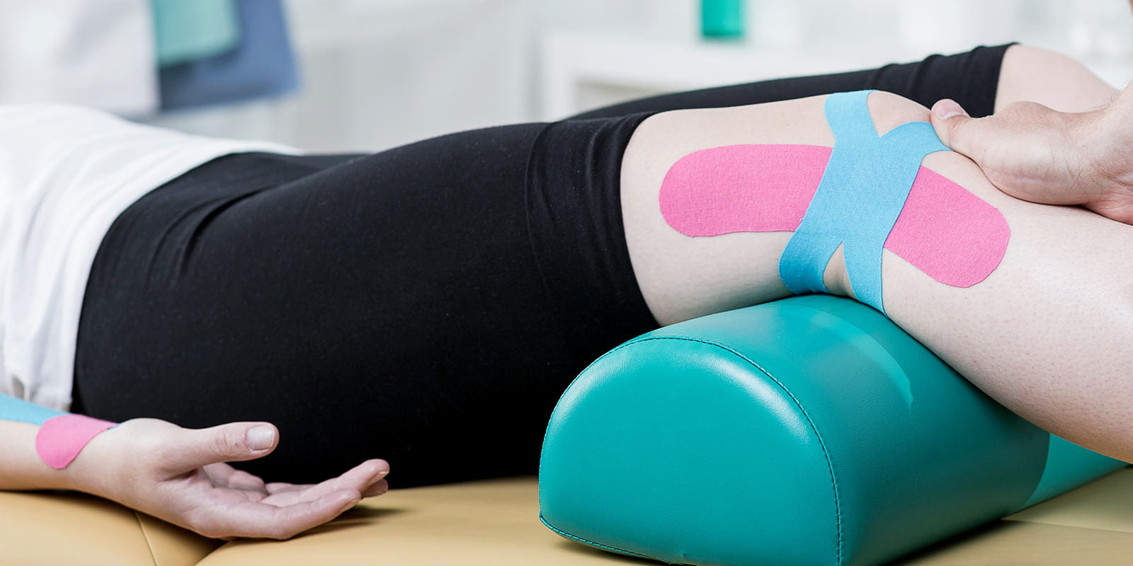 A provider conducting leg rehabilitation on female patient with knee pain