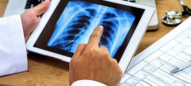 Doctor shows results to patient x-ray on tablet