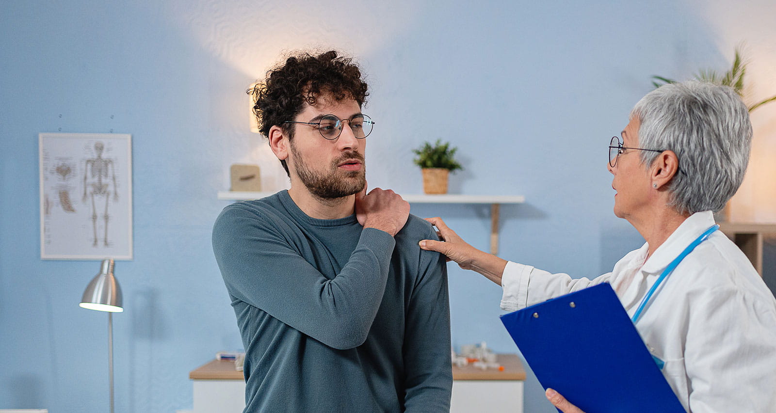 A man with shoulder pain being examined by a female physician