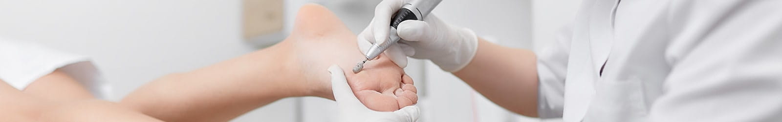 Podiatrist using special grinding equipment on patient's foot.