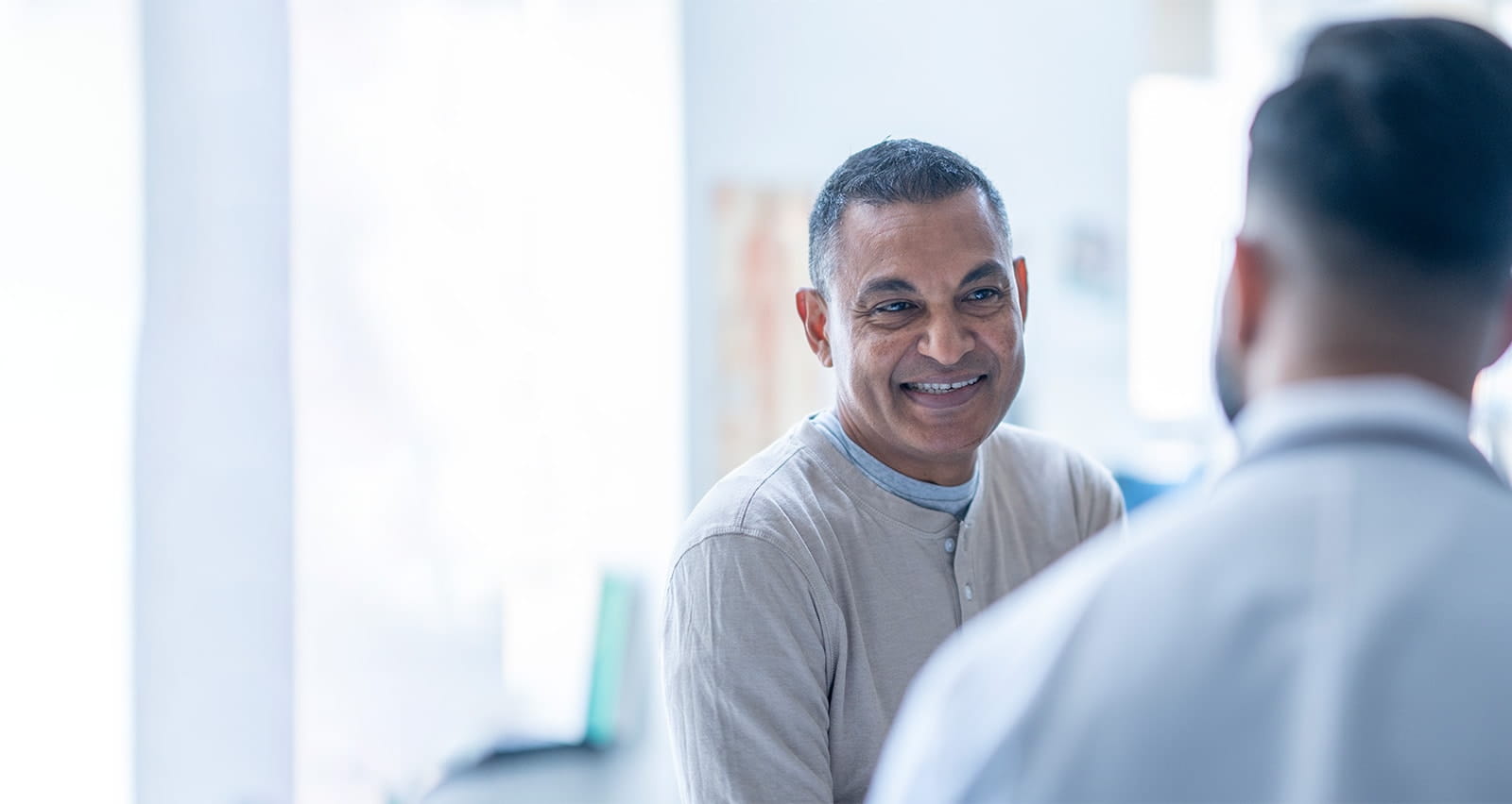 Male patient at an appointment with with male healthcare professional