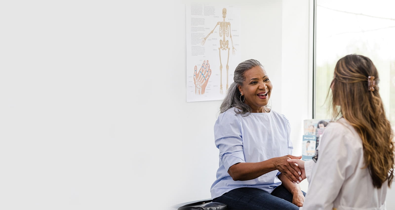 Female patient shakes hands with the female healthcare professional