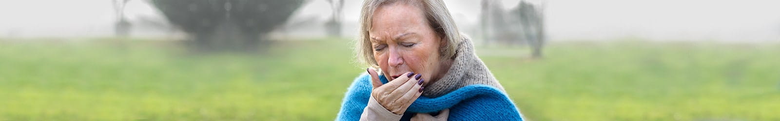 Woman coughing hard outside.