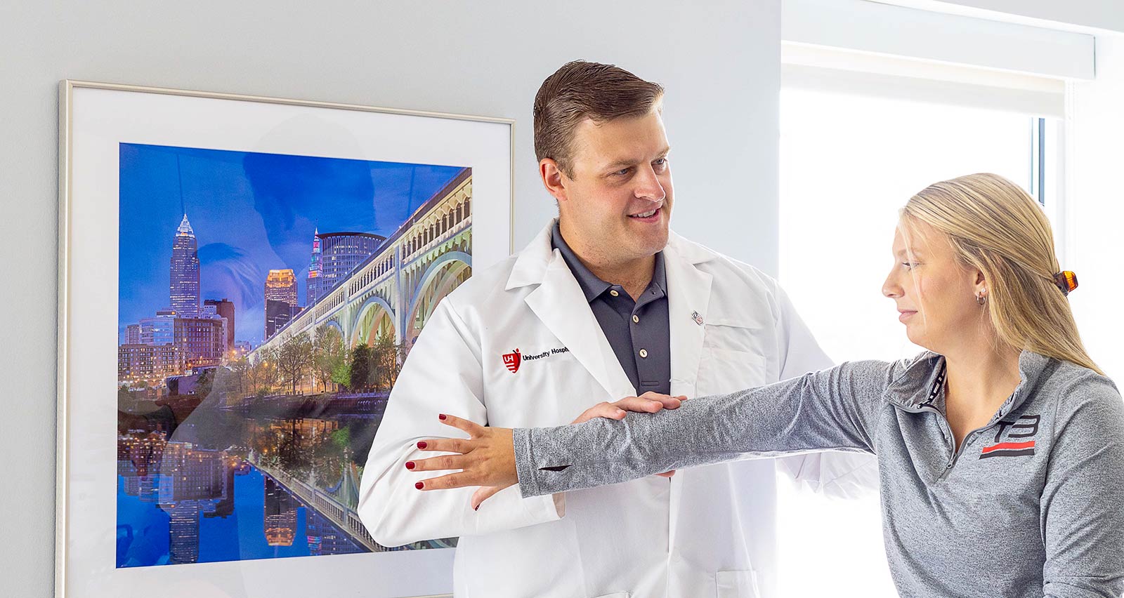 A young female patient receives therapy for her arm from Yianni Apostolakos, MD, MPH at a west side University Hospitals Orthopedics & Sports Medicine location