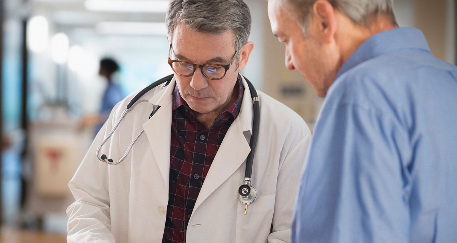 A doctor showing information to patient in hallway