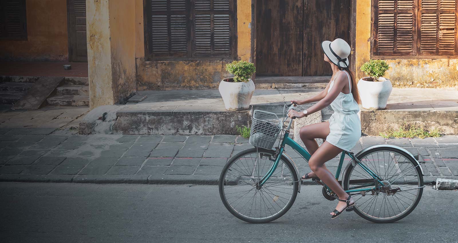 A young woman tourist cycling in the old district of Hoi An in Vietnam during the day