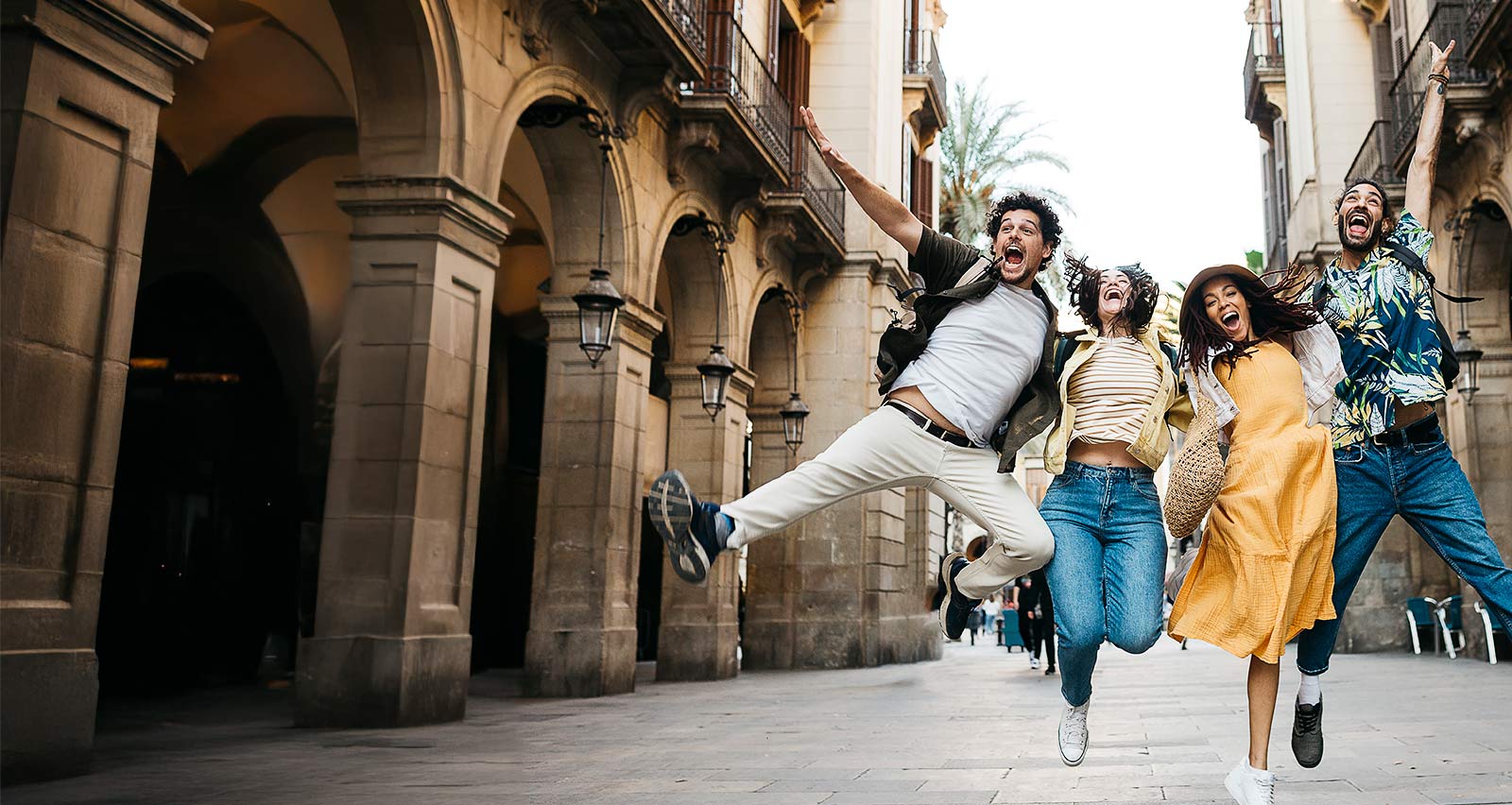 Young multiracial group of young tourists jumping on the street in Barcelona, Catalonia