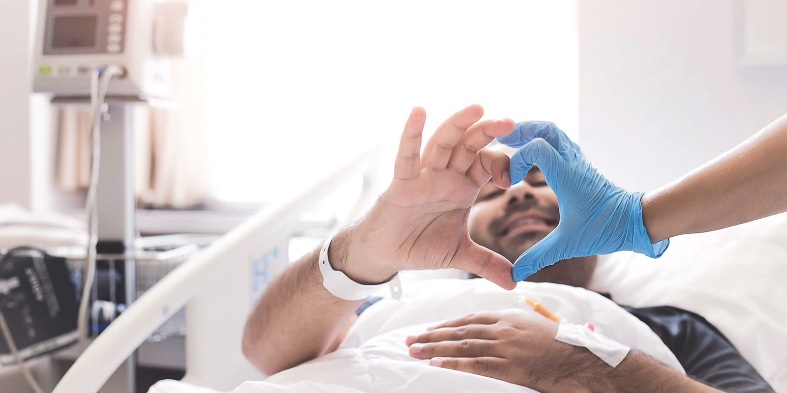 Patient and doctor making heart shape with hands