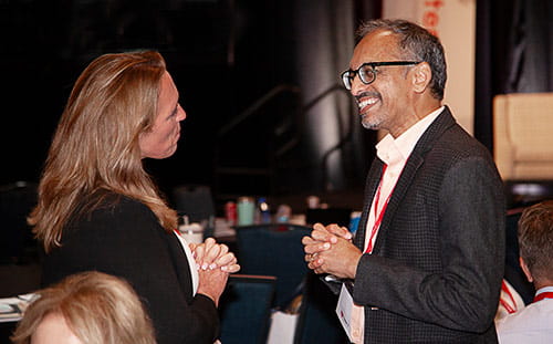 Two attendees have a conversation