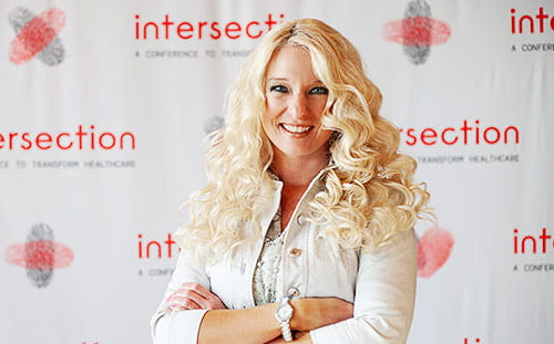 A woman poses in front of the Intersection banner