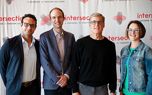 Attendees pose in front of the Intersection banner