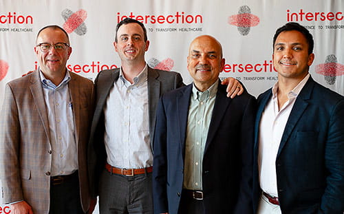 Attendees pose in front of the Intersection banner