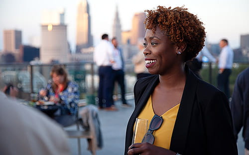 A smiling woman at the rooftop gathering