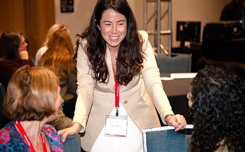 A woman greets attendees at the Intersection Conference