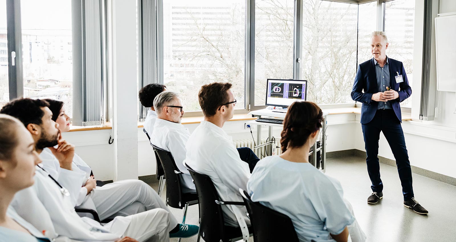 A group of medical students focusing during a hospital teaching seminar