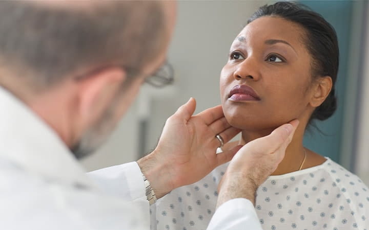Doctor examining a woman's throat